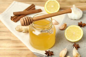 Concept of treatment colds with honey and garlic on  wooden background