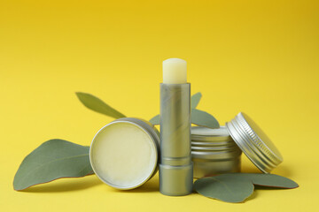 Hygienic lipstick and lip balm on yellow background