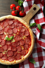 Concept of tasty food with Salami pizza on wooden background