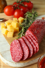 Сoncept of tasty food with salami sausage on wooden background
