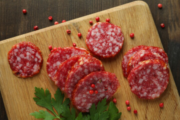 Сoncept of tasty food with salami sausage on wooden background