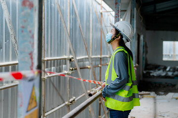 PORTRAIT, an Asian female engineer Wear a reflective vest and a white safety hat. Checking the machines at work construction site area