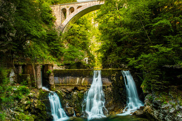 Vintgar Gorge in Slovenia. Stone Arch Rail Bridge over Waterfall