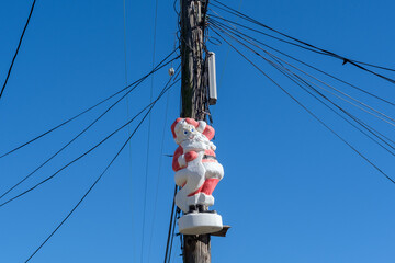 Santa Claus figure strapped to a utility pole as Christmas decoration
