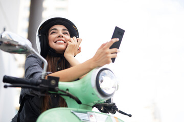 Fototapeta na wymiar Beautiful woman getting ready for a ride on scooter. Beautiful happy lady taking selfie photo..