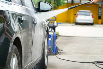 Wash the car with a high pressure washer in the exterior car wash.