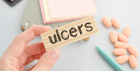Word ulcer from wooden blocks with stethoscope, healthcare and medical concept.