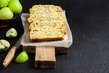 Apple and coconut loaf cake on wooden cutting board