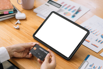 Close-up image of woman hands using tablet blank white screen and holding credit card. Online shopping concept.