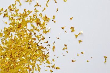 Gold glitter pieces of foil on white background