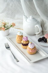 Assorted Miniature French Choux Pastry Dessert with teapot on the table