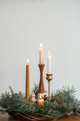 Christmas advent. Stylish candles burning in christmas wreath on wooden table. Winter holidays time