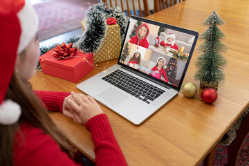 Naklejka na ściany i meble Caucasian woman in santa hat making laptop christmas group video call with four caucasian girls