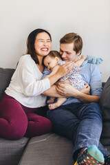 Cheerful Mother Embracing Man And Daughter