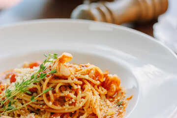 Spaghetti pasta with tomatoes and shrimps in a restaurant of italian food