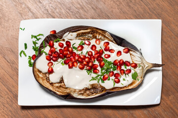 Grilled aubergines with tahini sauce and pomegranate seeds. High quality photo