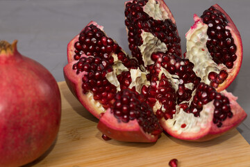 Frash pomegranate on a wooden desk, pomegranates in the background.