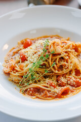 Spaghetti pasta with tomatoes and shrimps in a restaurant of italian food