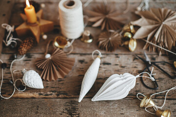 Christmas ornaments, bells, angel, stars, candle, thread, scissors on rustic wood. Merry Christmas