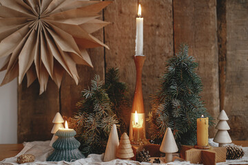 Christmas advent. Burning christmas candles, trees, paper star on rustic background. Happy holidays