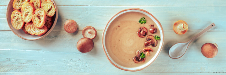 Mushroom soup panorama, overhead flat lay shot with ingredients and toasted bread, on a teal rustic...