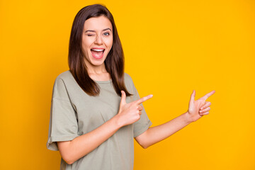 Photo of young happy excited smiling positive good moo girl wink eye point fingers copyspace isolated on yellow color background