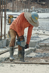 JOHOR, MALAYSIA -JANUARY 13, 2015: A construction worker hacking-casted concrete into small pieces. He using the heavy-duty mobile hacker machine.
