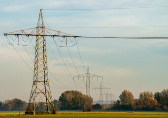 Electricity pylons on an autumn meadow at dawn