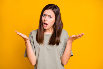 Photo of young lovely pretty shocked amazed surprised girl tell say news information isolated on yellow color background