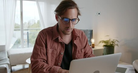 Caucasian male working from home typing on laptop