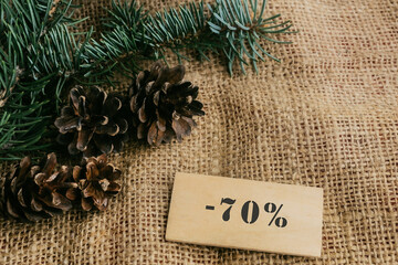 sale minus 70 percent. Christmas tree, cones, tinsel. Seasonal sale, big discounts. Black Friday...