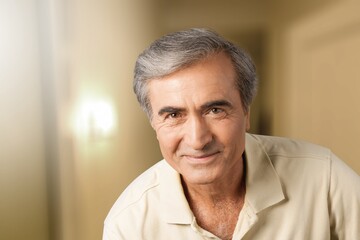 Portrait of beautiful smiling senior man posing at home room