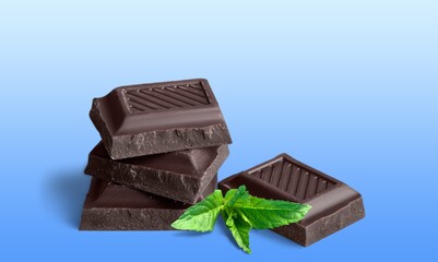 Milk chocolate and mint leaves on the desk