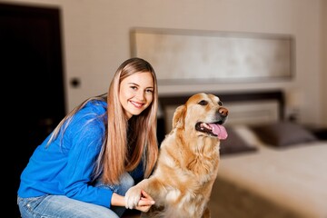 Fluffy dog with its owner young woman, happy playing while staying home,