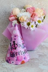 Party hat and delicate bouquet for birthday. Birthday celebration concept