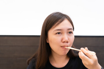 Happy Asian young woman enjoy eating Takoyaki on a dish.