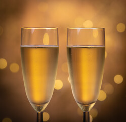 Champagne glasses over holiday bokeh blinking background, glasses with sparkling wine, celebration, party