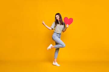 Fototapeta na wymiar Full size photo of attractive nice woman point finger empty space dream hold red paper heart isolated on yellow color background
