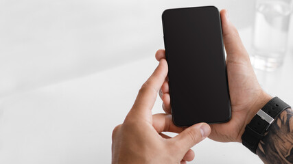 Hands of adult european guy checks social networks, app and chatting online in smartphone with empty screen