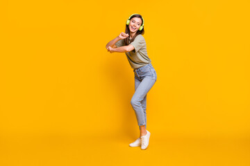 Fototapeta na wymiar Full length body size view of pretty funny cheerful girl listening melody dancing free time isolated over bright yellow color background