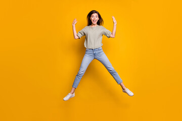 Fototapeta na wymiar Full size photo of happy cute shocked girl jump up air raise hands dream sale isolated on yellow color background