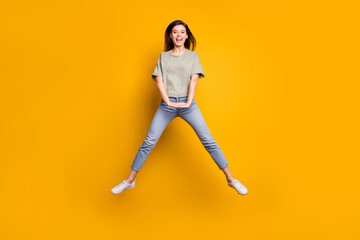 Fototapeta na wymiar Full length body size view of lovely funny skinny cheerful girl jumping having fun isolated over bright yellow color background