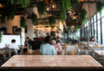 Empty wooden table top with lights bokeh on blur restaurant background.