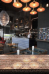 Empty wooden table top with lights bokeh on blur restaurant background.