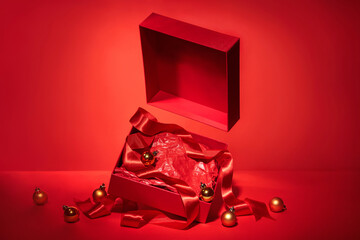Blank open red gift box with ribbon and Christmas decor.