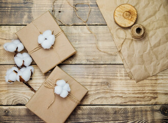 Boxes packed in kraft paper on a wooden background.Environmentally friendly material.Christmas and New Year.