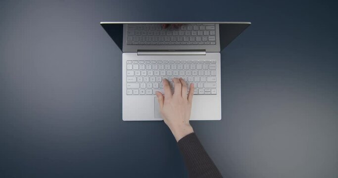 Minimalist workspace with laptop, tablet and woman typing on keyboard, top view. Flat home office desk. Workspace concept, working on a computer