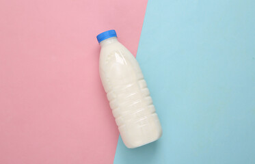 Milk bottle on a blue-pink pastel background. Top view