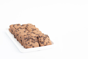 Square shaped Chocolate Chip Cookies Served In White Tray. Isolated On White Background With Copy Space For Custom Text. Front View Closeup And Selective Focus