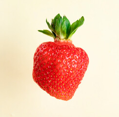 Strawberry isolated. Strawberry with leaf. A whole strawberry on a yellow background. Delicious background with strawberries.